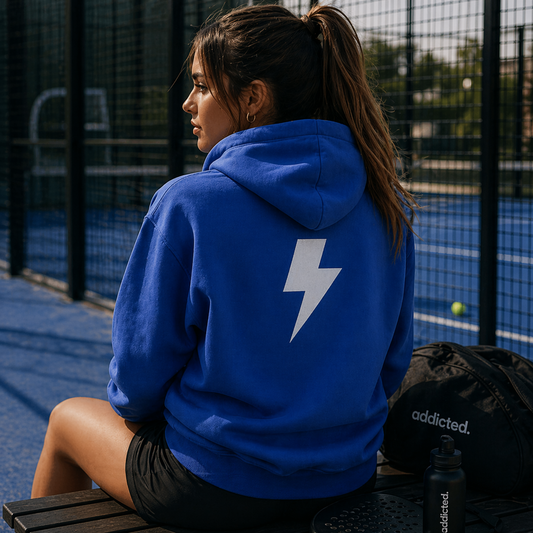 padel player in lightning bolt hoodie at padel court