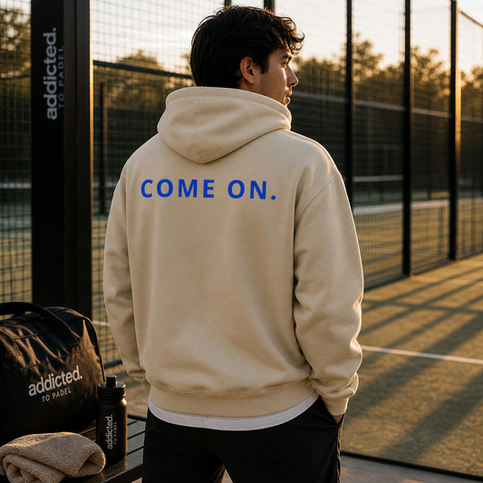 man at padel court with hoodie on saying come on 
