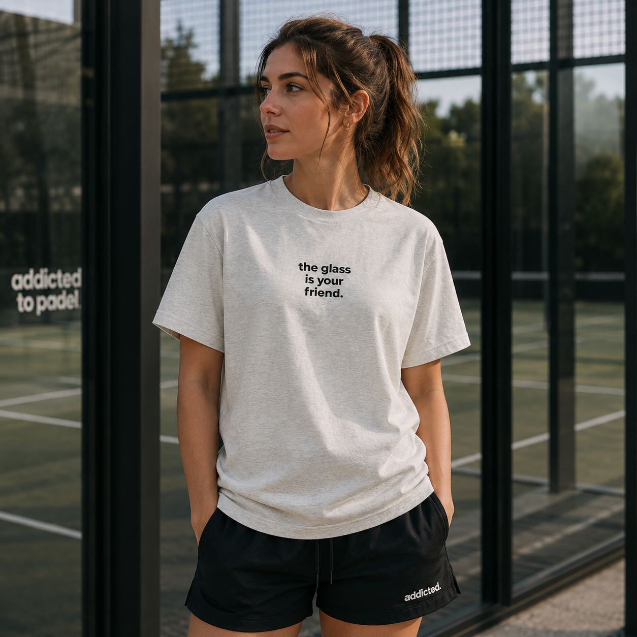 Woman wearing a white t-shirt with text on a tennis court